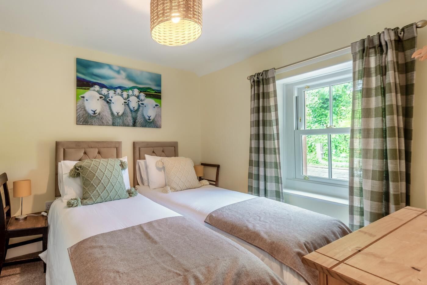 A double room with two beds, a window with curtains, a painting on the wall, and a bedside table with a lamp.