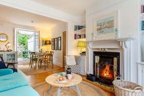 Ein gemütliches Wohnzimmer mit Kamin, Essbereich und Bücherregal.