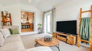A modern living room with a sofa, a coffee table, a TV, and a wooden TV stand. - 2 Bed in Kirkby-in-Furness (oc-s42634) (Kirkby Ireleth)