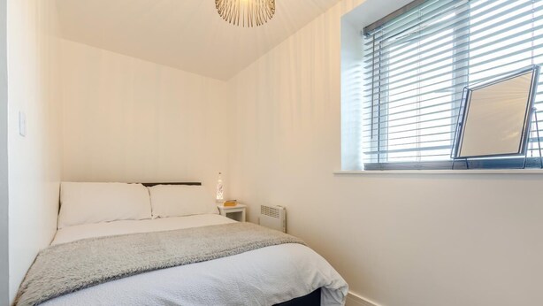 A bedroom with a bed, bedside table, lamp, and window with blinds. - 2 Bed in Kirkby-in-Furness (oc-s42634) (Kirkby Ireleth)
