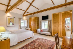 A bedroom with a bed, bedside table, chair, and a TV mounted on the wall. - 4 Bed in Wensley (oc-t45784) (Wensley)