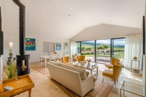 A spacious living room with a large sofa, dining area, and a view of the outdoors. - 4 Bed in Wensley (oc-t45784) (Wensley)