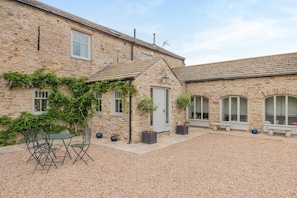 A stone building with a gravel courtyard, outdoor seating, and potted plants. - 4 Bed in Wensley (oc-t45784) (Wensley)