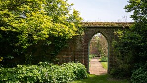 A stone bridge arching over a pathway surrounded by lush greenery. - 6 Bed in West Malling (oc-n45282) (Kings Hill)