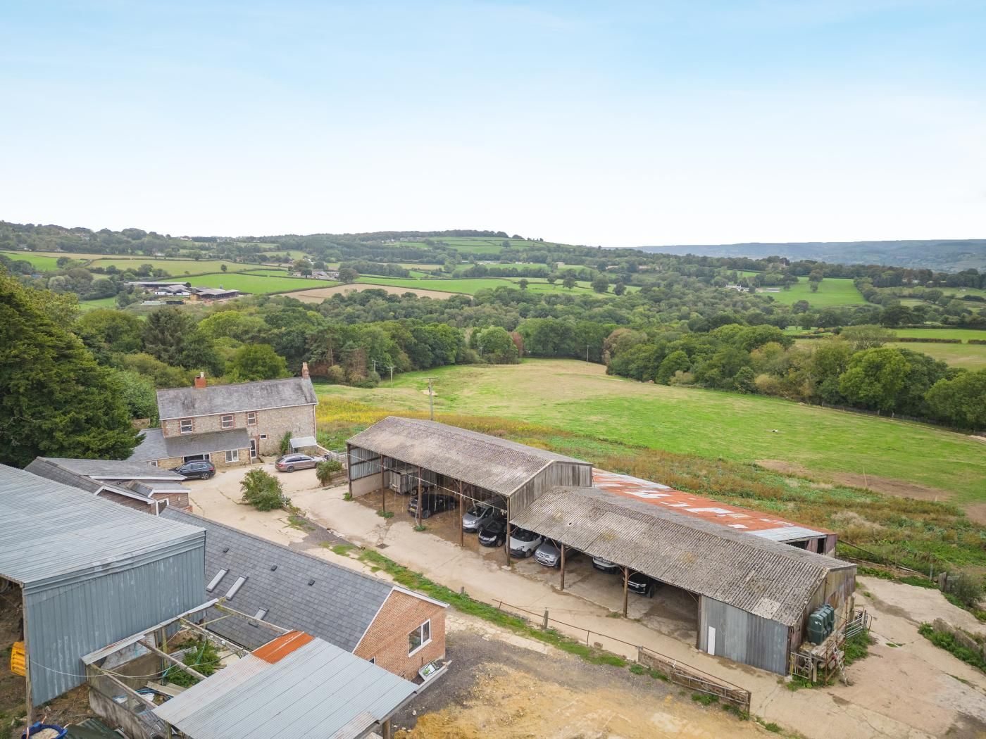 A rural property with multiple buildings, including a large barn and several smaller structures.