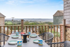 Ein Tisch im Freien mit Blick auf die Landschaft, umgeben von einer Holzbrüstung.