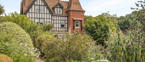 A Tudor-style house with a garden path leading to the entrance.