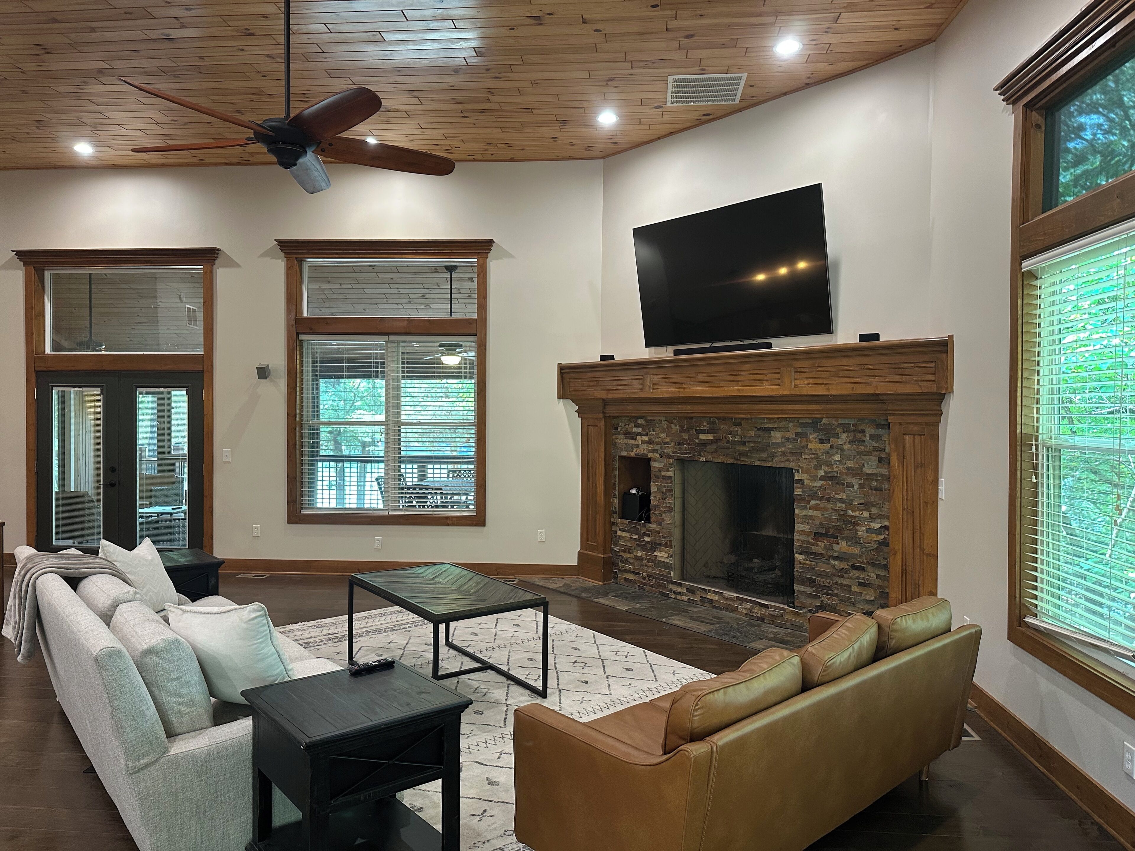A living room with a fireplace, a television, and a large window.