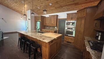 A kitchen with wooden cabinets, a granite countertop, and stainless steel appliances.