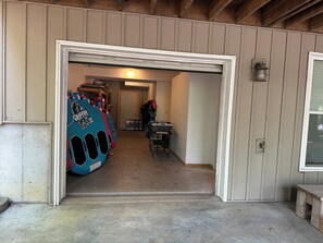 A garage entrance with a concrete floor, a wooden door frame, and a wall-mounted light fixture.