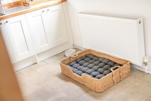 A kitchen with white cabinets, a white radiator, and a woven basket with a cushion on the floor. - 4 Bed in Ainthorpe (oc-m45794) (Danby)