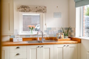 A kitchen with a window, a sink, cabinets, and a first aid kit. - 4 Bed in Ainthorpe (oc-m45794) (Danby)