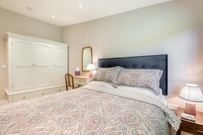 A bedroom with a bed, a dresser, a mirror, and a nightstand. - 1 Bed in Frampton Mansell (oc-t45435) (Frampton Mansell)