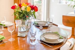 A dining table set with plates, glasses, cutlery, and a pitcher of water. - 1 Bed in Frampton Mansell (oc-t45435) (Frampton Mansell)