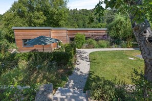 A modern wooden building with a gravel pathway leading to a grassy area. - 1 Bed in Frampton Mansell (oc-t45435) (Frampton Mansell)