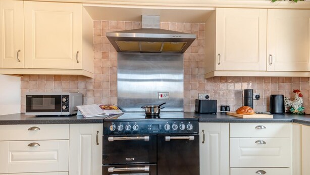 A kitchen with a stove, microwave, toaster, and a loaf of bread on the counter. - 2 Bed in Middle Rasen (oc-c45686) (Middle Rasen)