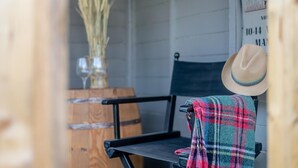 A wooden bench with a plaid blanket draped over it, a rustic vase with dried plants, and a hat leaning against the wall. - 3 Bed in Marden (oc-l45561) (Horsmonden)