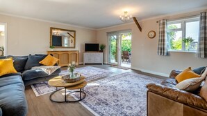 A living room with a sofa, armchair, coffee table, and a television. - 3 Bed in Marden (oc-l45561) (Horsmonden)