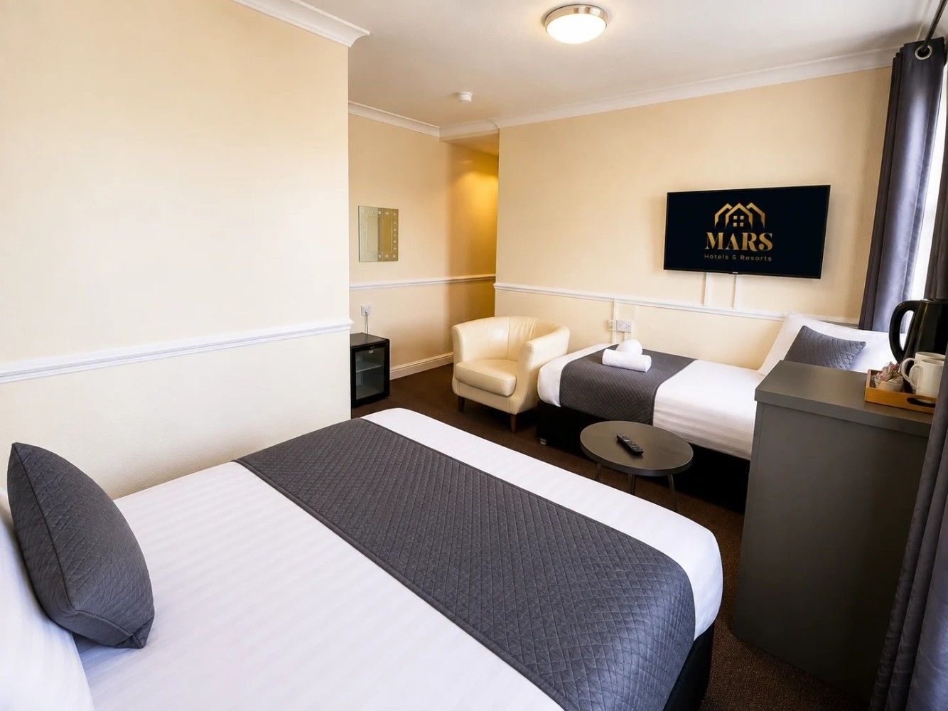 Une chambre d’hôtel avec un lit, un bureau, une chaise et un canapé.