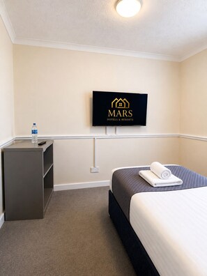 A hotel room with a bed, a desk, a water bottle, and a television displaying the hotel's logo. - Blackpool Seaview Hotel (Blackpool)