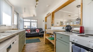 A compact kitchen with a wooden countertop, a stove, and a sink. - 3 Bed in Heacham (oc-v45689) (The Beach)