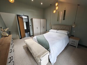 Ein Schlafzimmer mit Bett, Nachttischen, einem Kleiderschrank und einer Bank.