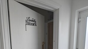 A hallway with a door labeled 'Laundry Room' and a wooden door in the background. - 1 Bed in Brixham (oc-f45535) (Brixham)