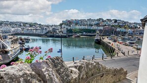 A coastal town with a harbor, stone walls, and a view of colorful buildings. - 1 Bed in Brixham (oc-f45535) (Brixham)