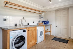 A laundry room with two washing machines, a sink, and a drying rack. - 4 Bed in Wharton (oc-h45870) (Wharton)