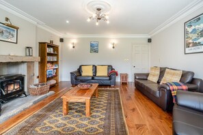 A living room with a fireplace, two sofas, a coffee table, and a patterned rug. - 4 Bed in Wharton (oc-h45870) (Wharton)