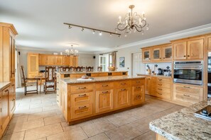 A spacious kitchen with wooden cabinetry, a central island, and a built-in oven. - 4 Bed in Wharton (oc-h45870) (Wharton)