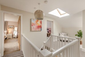 A modern interior with a staircase, a ceiling light fixture, and a painting. - 3 Bed in Grizebeck (oc-b45345) (Kirkby Ireleth)