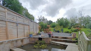 A garden with a pond, wooden fence, and outdoor seating. - 3 Bed in Grizebeck (oc-b45345) (Kirkby Ireleth)