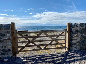 A wooden gate leading to a rocky beach with a view of the sea. - 3 Bed in Port William (oc-s45456) (Port William)