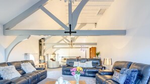 Ein geräumiges Wohnzimmer mit Ledersofas, einem Holztisch und einer Kandelaber.