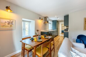 Eine moderne Küche mit Essbereich, Holzmöbeln und Blick ins Freie.