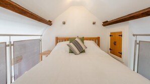 A bedroom with a bed, wooden headboard, and a window with a view. - 1 Bed in Ambleside (oc-a45864) (Ambleside)