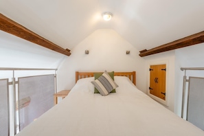 Ein Schlafzimmer mit einem Bett, einem Holzkopfende und einem Fenster mit Blick.
