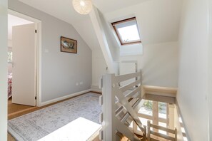 A spacious room with a sloped ceiling, a skylight, and a view of the outdoors. - 4 Bed in Beccles (oc-b45848) (Beccles)