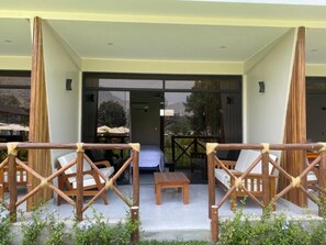 An outdoor seating area with wooden furniture and a view of the interior.