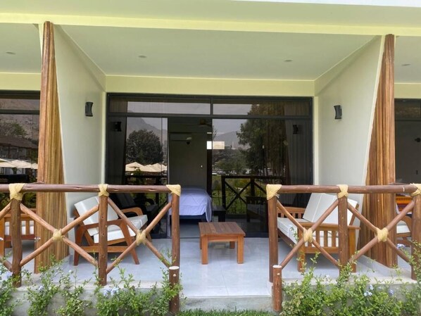 An outdoor seating area with wooden furniture and a view of the interior.