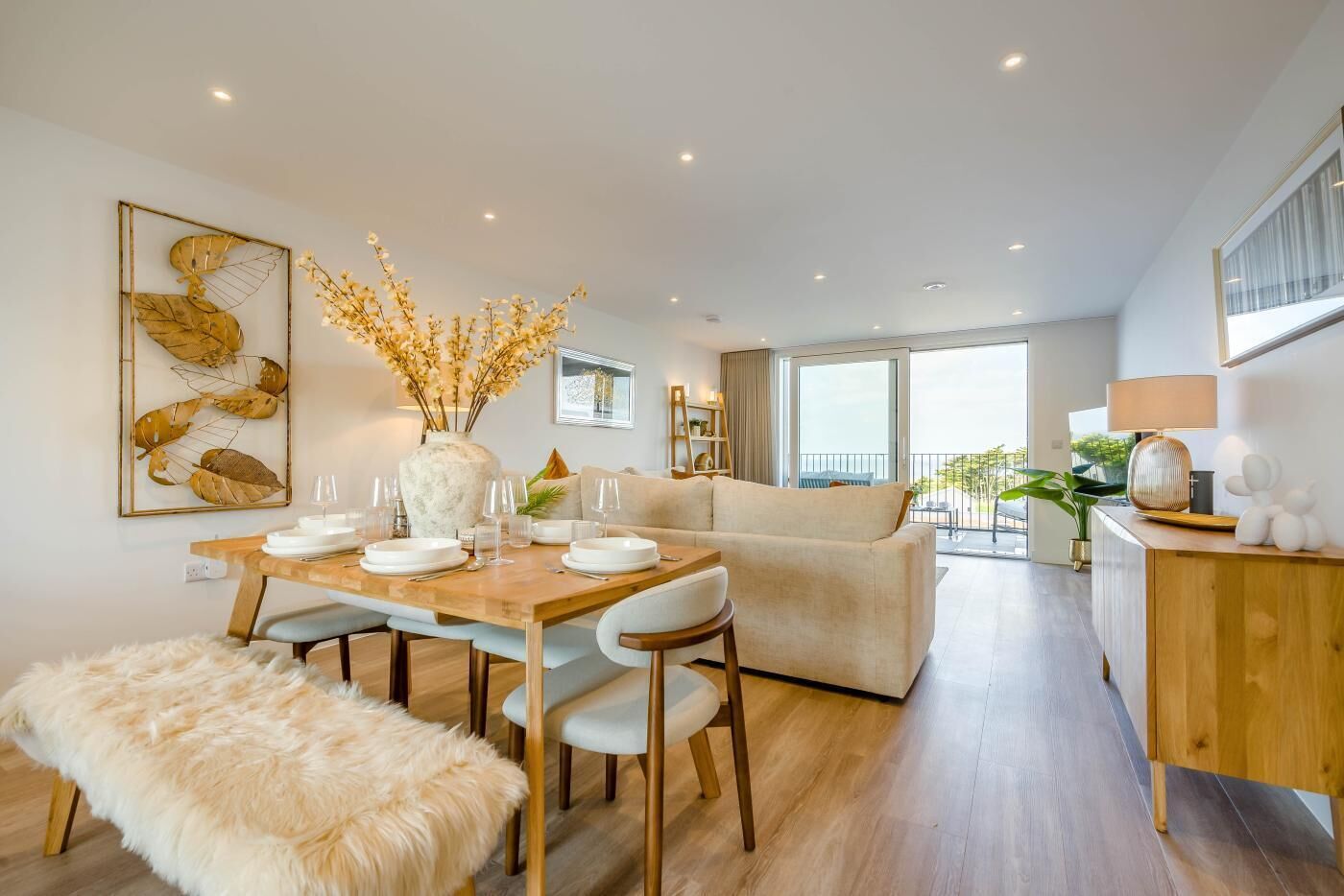 Un salon moderne comprenant un coin repas, un canapé, une table basse et une vue sur l’extérieur.