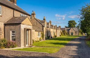 A row of traditional stone houses with a gravel driveway and well-maintained lawns. - 3 Bed in Rock (oc-r45594) (Rock)