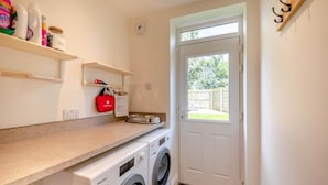 A laundry area with a washing machine, a dryer, a shelf with cleaning supplies, and a first aid kit. - 3 Bed in Rock (oc-r45594) (Rock)