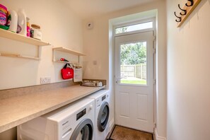 A laundry area with a washing machine, a dryer, a shelf with cleaning supplies, and a first aid kit. - 3 Bed in Rock (oc-r45594) (Rock)