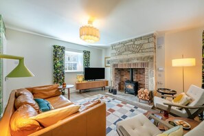 A cozy living room with a fireplace, leather sofa, and a television. - 3 Bed in Rock (oc-r45594) (Rock)