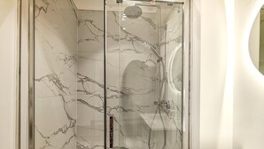 Eine Duschkabine mit Handbrause und Armaturen an der Wand.