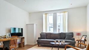 Ein modernes Wohnzimmer mit einer Couch, einem Couchtisch und einem Fernseher.