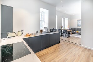 Une cuisine moderne dotée d’un îlot central, d’appareils électroménagers intégrés et d’un coin repas offrant une vue agréable.