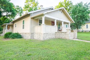 A single-story house with a stone foundation, a front porch, and a small front yard. - Cozy 2-bedroom in Cotter with walking distance to shopping, river, and food. (Cotter)